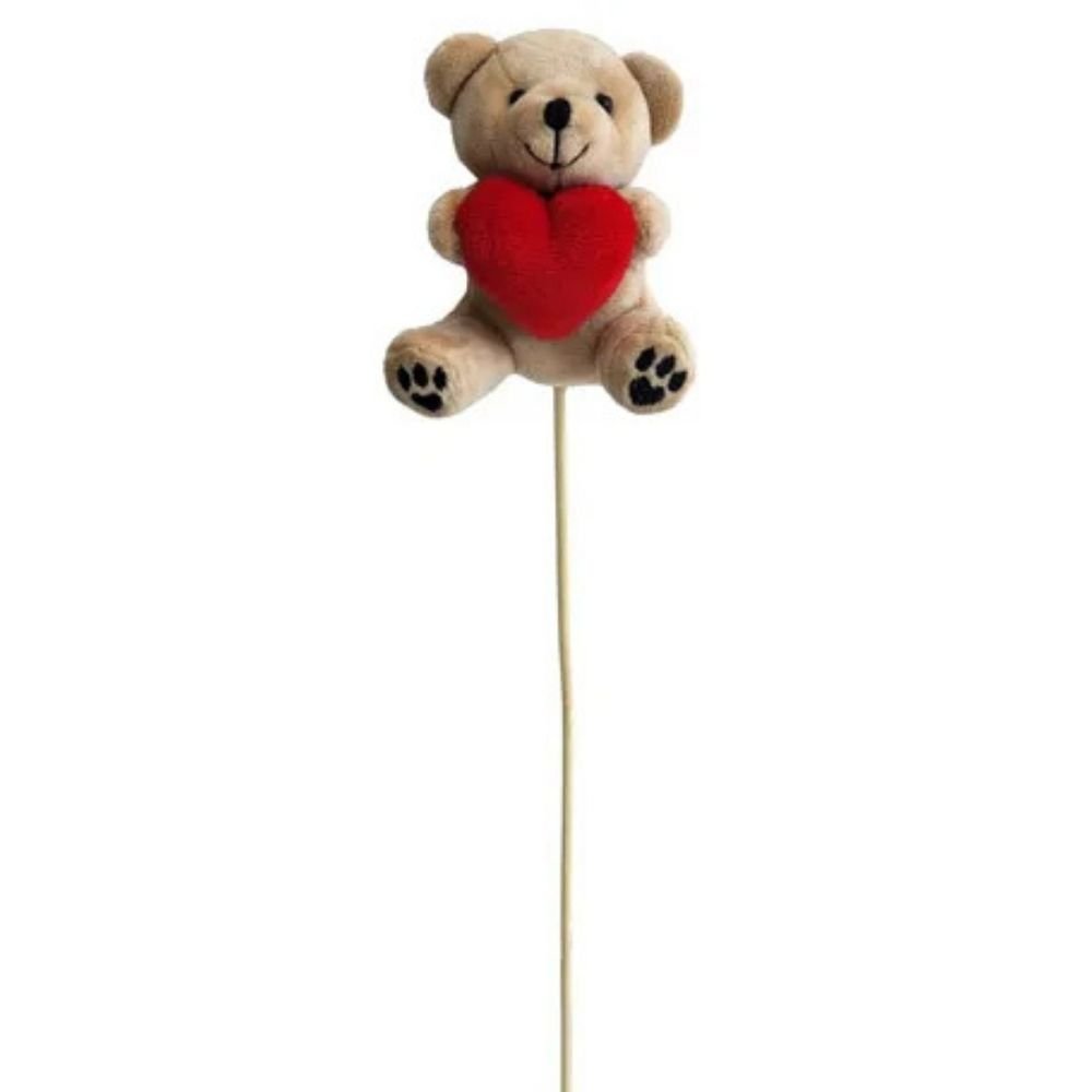 A small beige teddy bear plush holding a bright red heart.