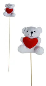 Two teddy bears with red hearts on sticks against a white background